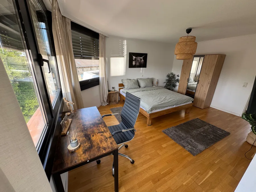 Modernes Monteurzimmer in NRW mit Schreibtisch, Doppelbett und großen Fenstern