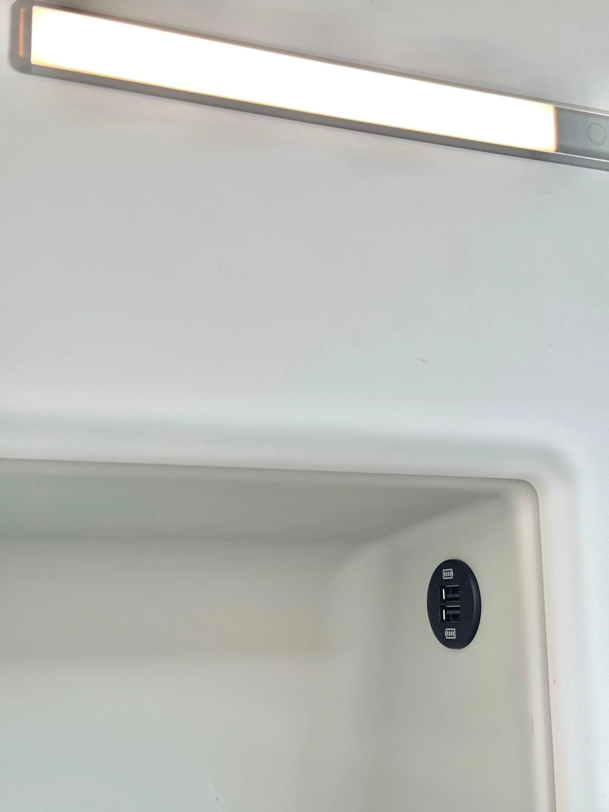 Integrierte USB-Ladeanschlüsse und LED-Leselampe im Schlafbereich des VW Grand California